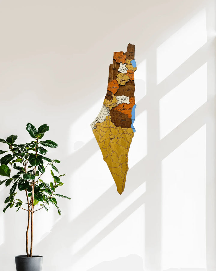 Decorative wall art with a cracked pattern on a white wall next to a potted plant.