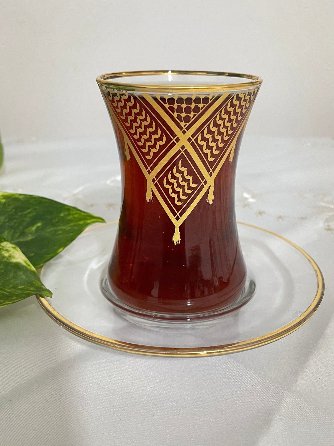 Acquire elegance and heritage with this tea glass set, designed to add a touch of authentic beauty to your tea-drinking experience. Each glass is adorned with intricate Palestinian Keffiyeh patterns, blending luxury with authenticity. The set comprises 6 elegant tea glasses and 6 matching saucers, all embellished with enhancing rims. Available in luxurious colors: radiant golden, a distinctive golden and black combination, or elegant silver to suit various tastes and decors.