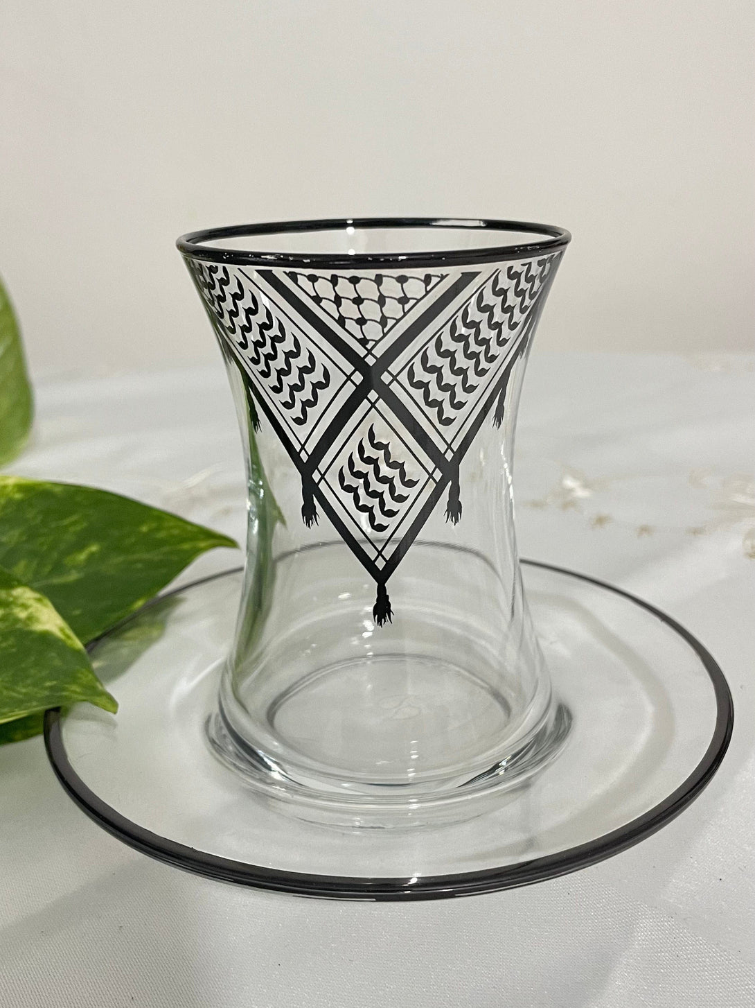 Acquire elegance and heritage with this tea glass set, designed to add a touch of authentic beauty to your tea-drinking experience. Each glass is adorned with intricate Palestinian Keffiyeh patterns, blending luxury with authenticity. The set comprises 6 elegant tea glasses and 6 matching saucers, all embellished with enhancing rims. Available in luxurious colors: radiant golden, a distinctive golden and black combination, or elegant silver to suit various tastes and decors.