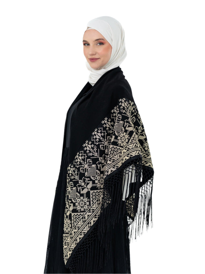 Shine with unique elegance with this luxurious shawl, which combines the splendor of classic black with the beauty of authentic Palestinian embroidery in radiant gold.