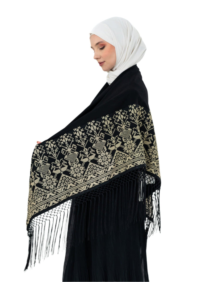 Shine with unique elegance with this luxurious shawl, which combines the splendor of classic black with the beauty of authentic Palestinian embroidery in radiant gold.