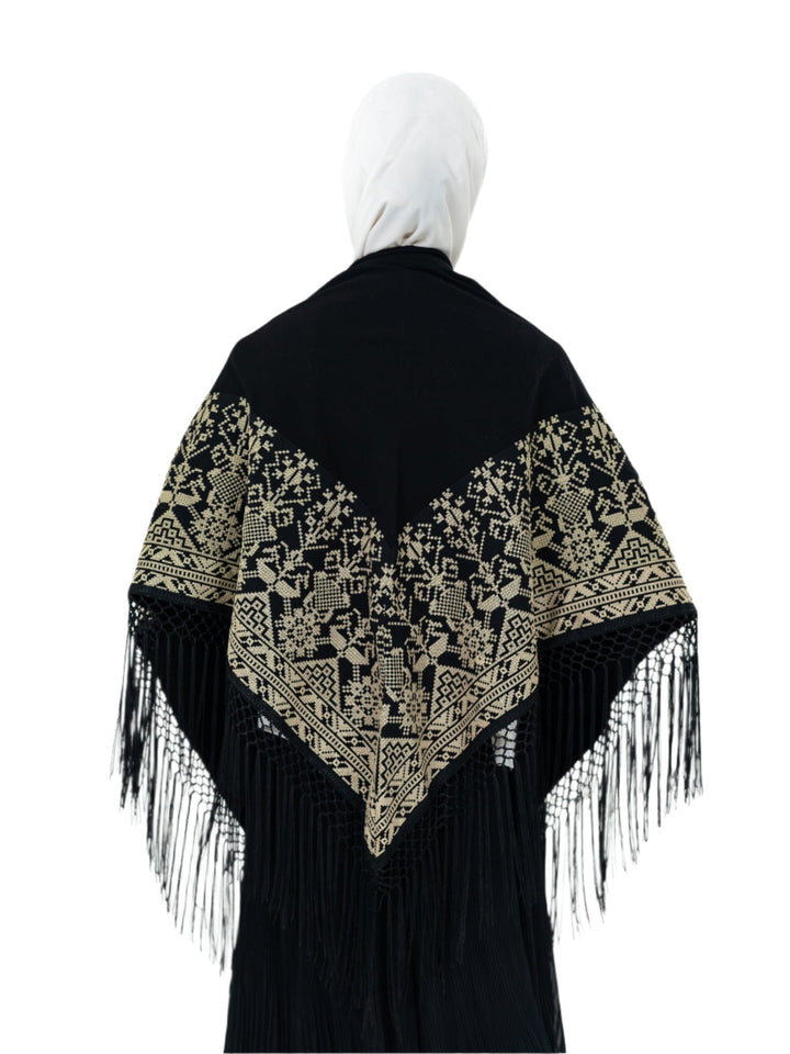 Shine with unique elegance with this luxurious shawl, which combines the splendor of classic black with the beauty of authentic Palestinian embroidery in radiant gold.
