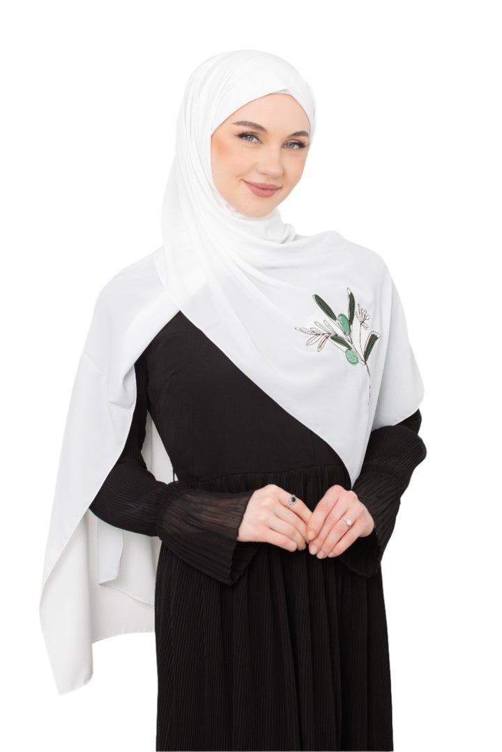 Discover expressive elegance with this luxurious White Shawl , meticulously crafted from high-quality polyester that offers a soft touch and perfect drape. Measuring 70 x 180 cm, the Shawl is versatile for various styling preferences. It is adorned with exquisite and detailed embroidery of a vibrant green olive branch, which is not merely an embellishment, but a profound symbol of peace, resilience, and a deep connection to the land and the rich Palestinian identity. Wear this Shawl&nbsp;to express your ref