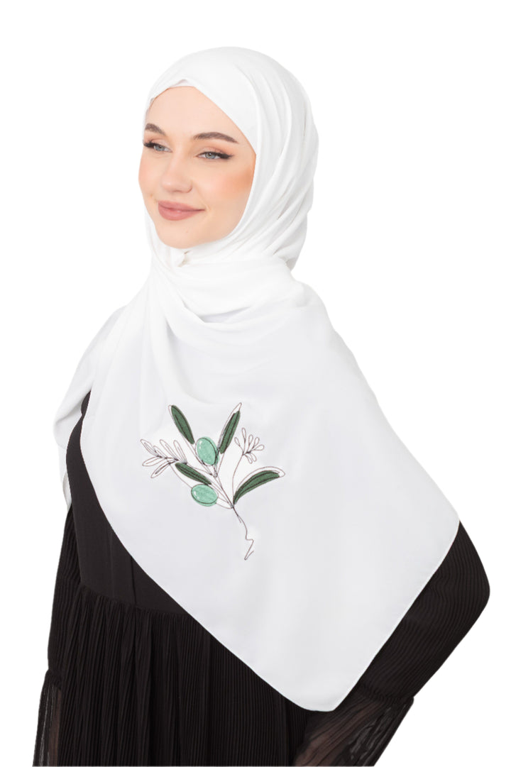 Discover expressive elegance with this luxurious White Shawl , meticulously crafted from high-quality polyester that offers a soft touch and perfect drape. Measuring 70 x 180 cm, the Shawl is versatile for various styling preferences. It is adorned with exquisite and detailed embroidery of a vibrant green olive branch, which is not merely an embellishment, but a profound symbol of peace, resilience, and a deep connection to the land and the rich Palestinian identity. Wear this Shawl&nbsp;to express your ref