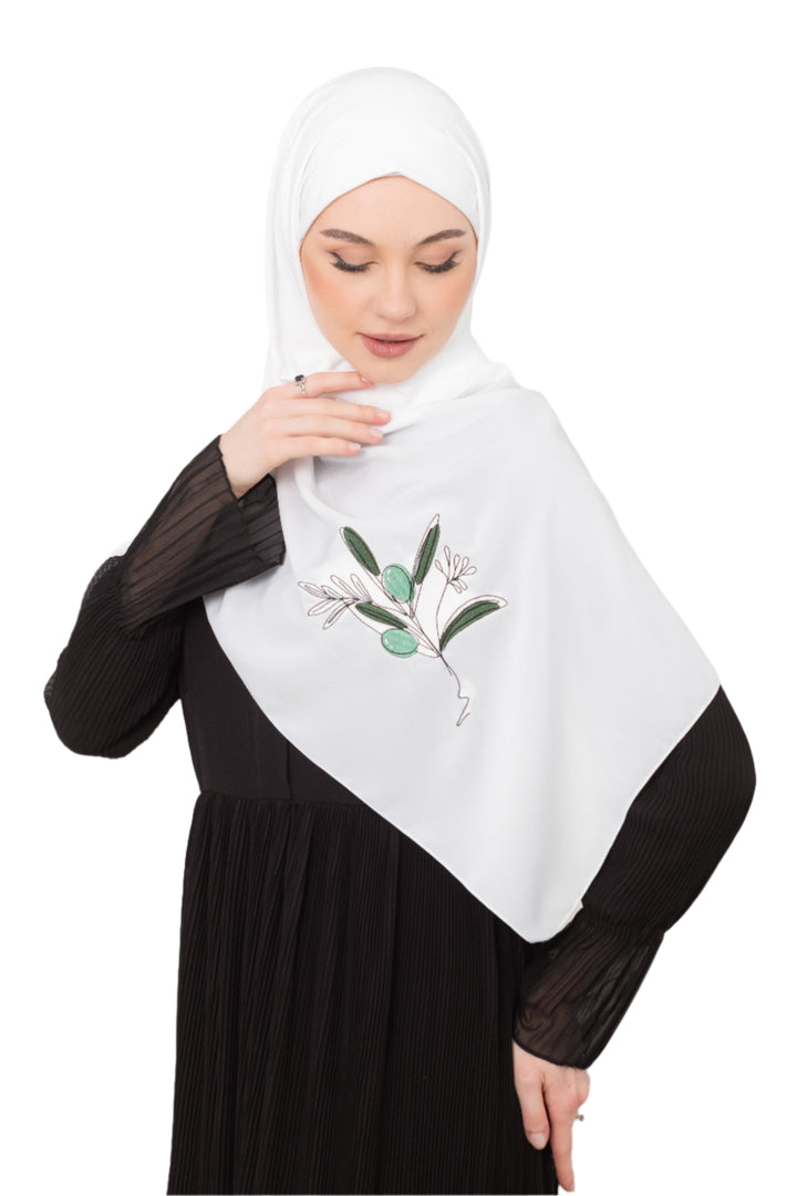 Discover expressive elegance with this luxurious White Shawl , meticulously crafted from high-quality polyester that offers a soft touch and perfect drape. Measuring 70 x 180 cm, the Shawl is versatile for various styling preferences. It is adorned with exquisite and detailed embroidery of a vibrant green olive branch, which is not merely an embellishment, but a profound symbol of peace, resilience, and a deep connection to the land and the rich Palestinian identity. Wear this Shawl&nbsp;to express your ref
