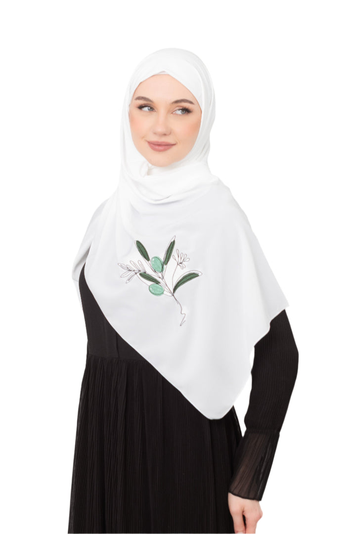 Discover expressive elegance with this luxurious White Shawl , meticulously crafted from high-quality polyester that offers a soft touch and perfect drape. Measuring 70 x 180 cm, the Shawl is versatile for various styling preferences. It is adorned with exquisite and detailed embroidery of a vibrant green olive branch, which is not merely an embellishment, but a profound symbol of peace, resilience, and a deep connection to the land and the rich Palestinian identity. Wear this Shawl&nbsp;to express your ref