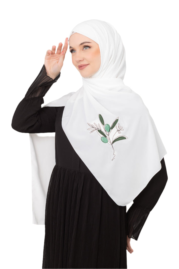 Discover expressive elegance with this luxurious White Shawl , meticulously crafted from high-quality polyester that offers a soft touch and perfect drape. Measuring 70 x 180 cm, the Shawl is versatile for various styling preferences. It is adorned with exquisite and detailed embroidery of a vibrant green olive branch, which is not merely an embellishment, but a profound symbol of peace, resilience, and a deep connection to the land and the rich Palestinian identity. Wear this Shawl&nbsp;to express your ref