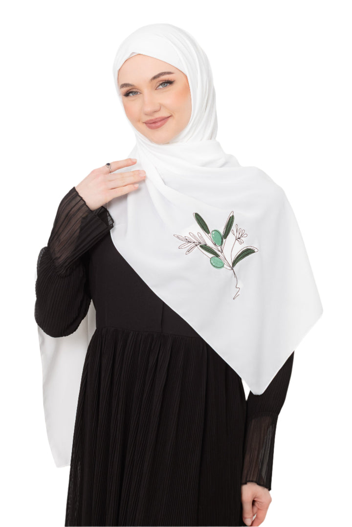 Discover expressive elegance with this luxurious White Shawl , meticulously crafted from high-quality polyester that offers a soft touch and perfect drape. Measuring 70 x 180 cm, the Shawl is versatile for various styling preferences. It is adorned with exquisite and detailed embroidery of a vibrant green olive branch, which is not merely an embellishment, but a profound symbol of peace, resilience, and a deep connection to the land and the rich Palestinian identity. Wear this Shawl&nbsp;to express your ref