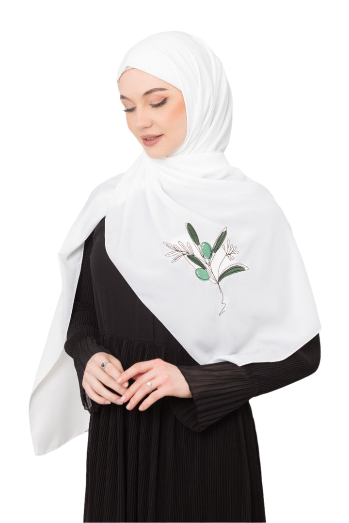 Discover expressive elegance with this luxurious White Shawl , meticulously crafted from high-quality polyester that offers a soft touch and perfect drape. Measuring 70 x 180 cm, the Shawl is versatile for various styling preferences. It is adorned with exquisite and detailed embroidery of a vibrant green olive branch, which is not merely an embellishment, but a profound symbol of peace, resilience, and a deep connection to the land and the rich Palestinian identity. Wear this Shawl&nbsp;to express your ref