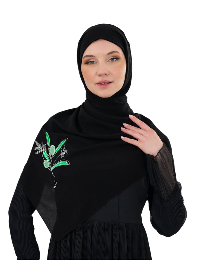 Discover expressive elegance with this luxurious black scarf, meticulously crafted from high-quality polyester that offers a soft touch and perfect drape. Measuring 70 x 180 cm, the scarf is versatile for various styling preferences. It is adorned with exquisite and detailed embroidery of a vibrant green olive branch, which is not merely an embellishment, but a profound symbol of peace, resilience, and a deep connection to the land and the rich Palestinian identity. Wear this scarf to express your refined t