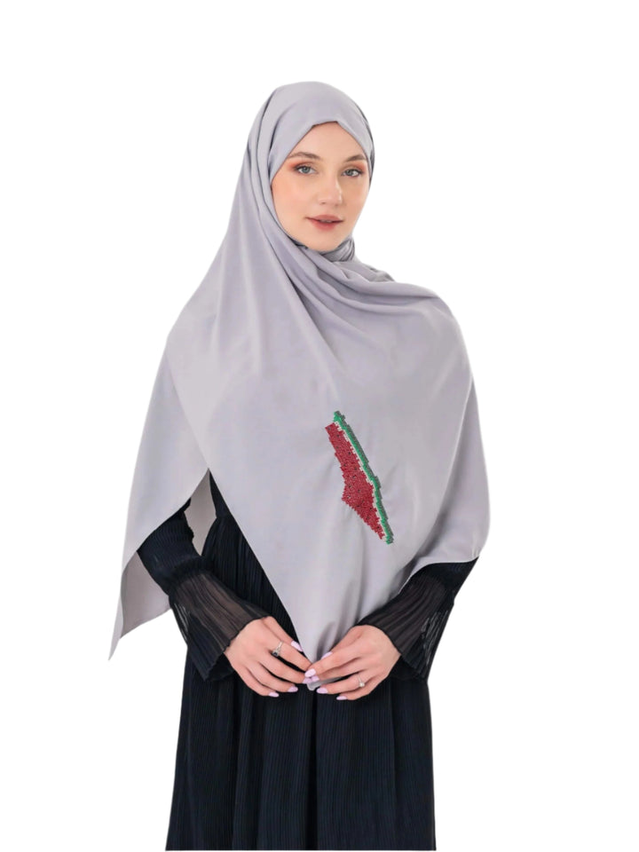 An elegant light grey scarf, made from high-quality polyester and measuring 70 x 180 cm. It features unique and beautiful embroidery of the map of Palestine, in colors inspired by the watermelon (red, green, black, and white), which has become a symbol of resistance and connection to Palestinian identity. This scarf adds a distinctive touch of elegance and deep meaning to your look.