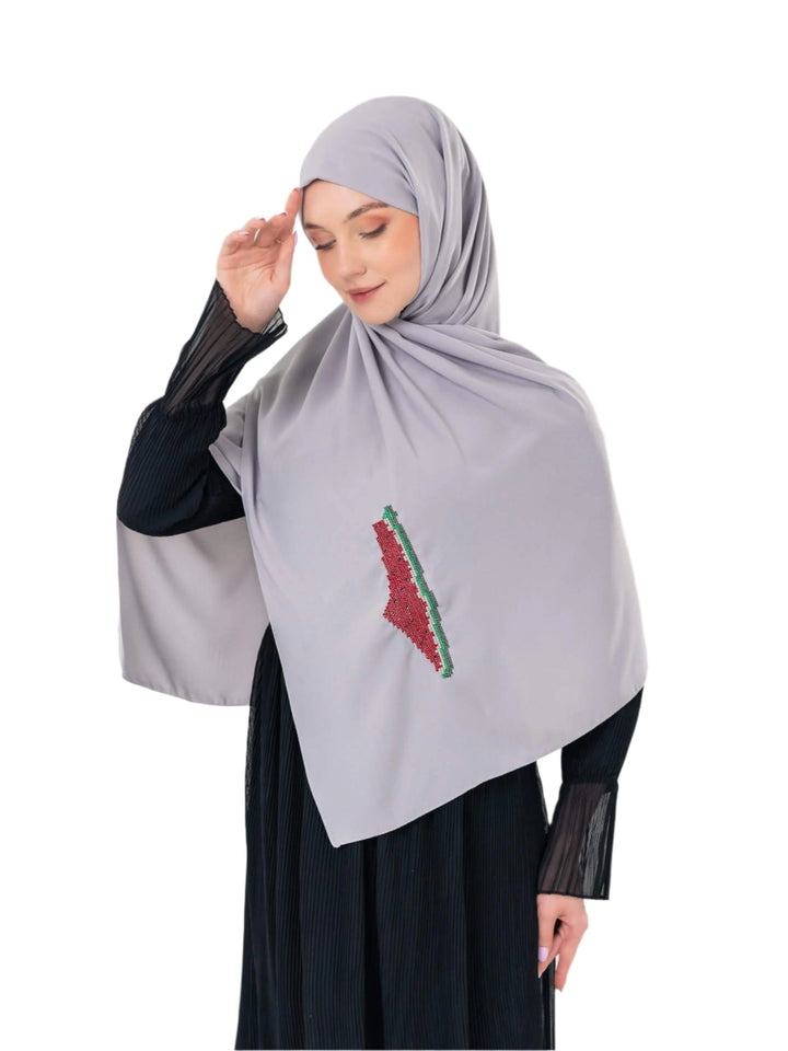 An elegant light grey scarf, made from high-quality polyester and measuring 70 x 180 cm. It features unique and beautiful embroidery of the map of Palestine, in colors inspired by the watermelon (red, green, black, and white), which has become a symbol of resistance and connection to Palestinian identity. This scarf adds a distinctive touch of elegance and deep meaning to your look.