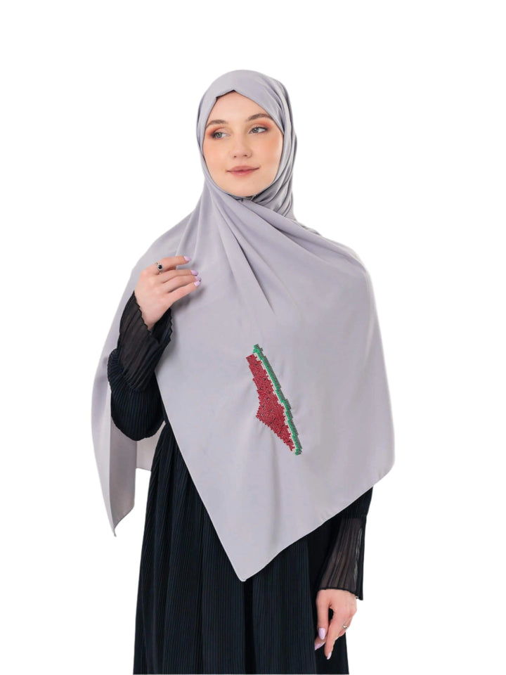An elegant light grey scarf, made from high-quality polyester and measuring 70 x 180 cm. It features unique and beautiful embroidery of the map of Palestine, in colors inspired by the watermelon (red, green, black, and white), which has become a symbol of resistance and connection to Palestinian identity. This scarf adds a distinctive touch of elegance and deep meaning to your look.