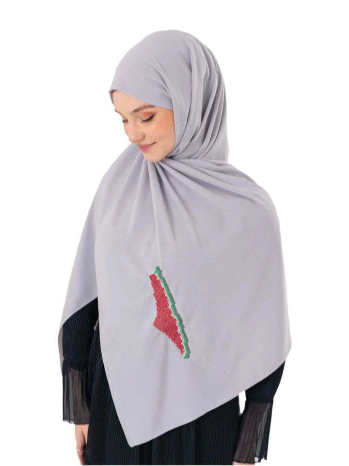 An elegant light grey scarf, made from high-quality polyester and measuring 70 x 180 cm. It features unique and beautiful embroidery of the map of Palestine, in colors inspired by the watermelon (red, green, black, and white), which has become a symbol of resistance and connection to Palestinian identity. This scarf adds a distinctive touch of elegance and deep meaning to your look.