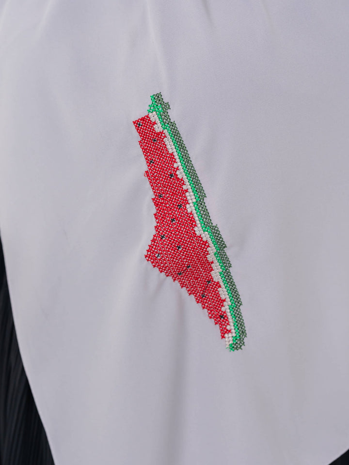 An elegant light grey scarf, made from high-quality polyester and measuring 70 x 180 cm. It features unique and beautiful embroidery of the map of Palestine, in colors inspired by the watermelon (red, green, black, and white), which has become a symbol of resistance and connection to Palestinian identity. This scarf adds a distinctive touch of elegance and deep meaning to your look.