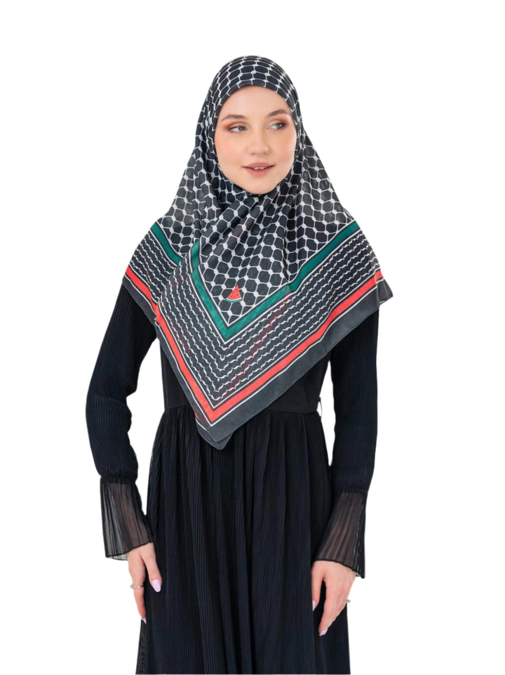 Woman wearing a black hijab with green and red patterns on a white background