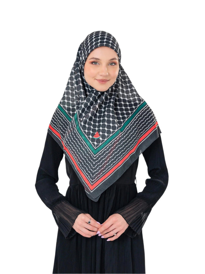 Woman wearing a patterned hijab and black dress on a white background