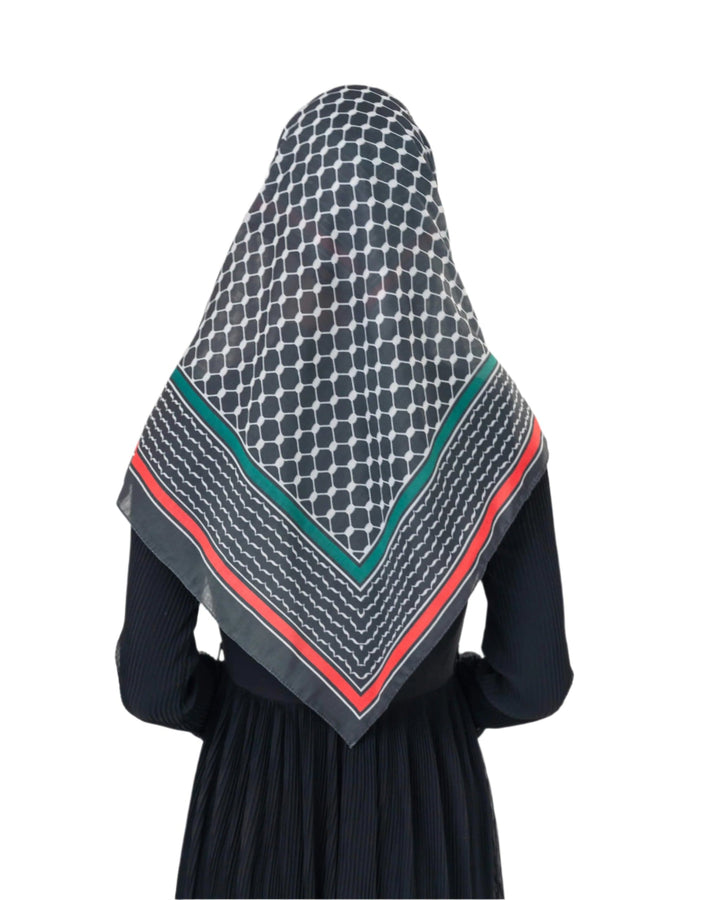 Person wearing a patterned headscarf on a plain background