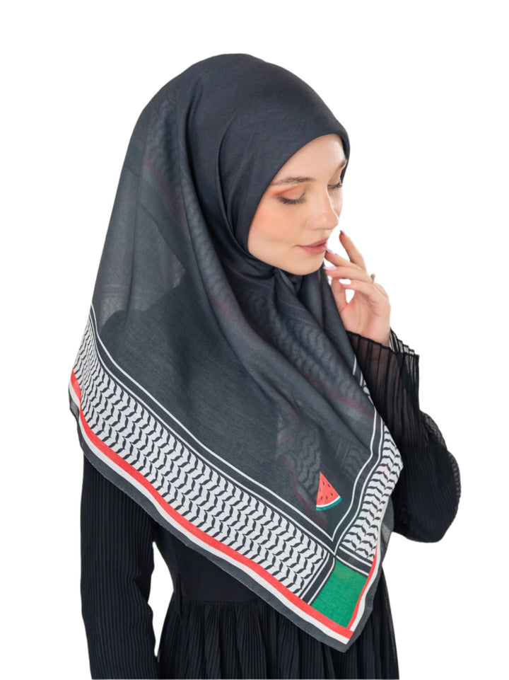 Woman wearing a dark hijab with a geometric pattern on a white background
