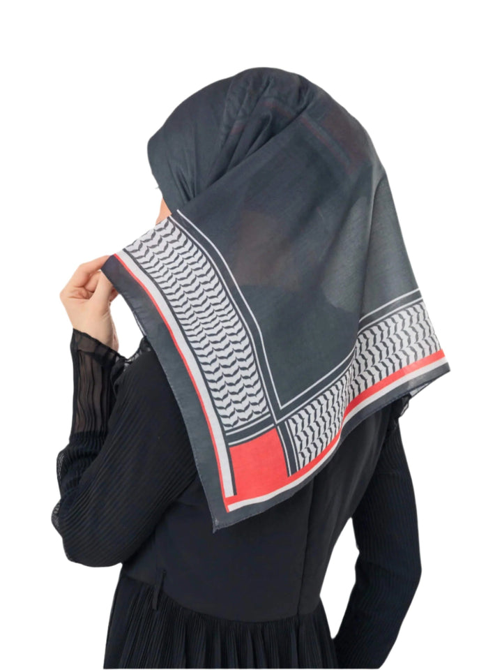 Person wearing a dark hijab with a geometric pattern on a white background