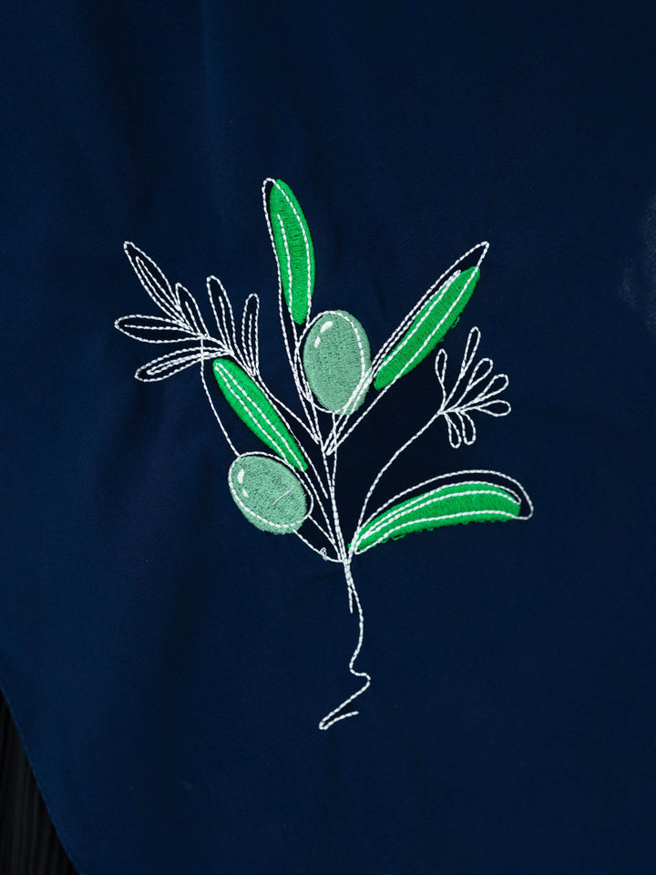 Embroidered design of an olive branch on a dark fabric background