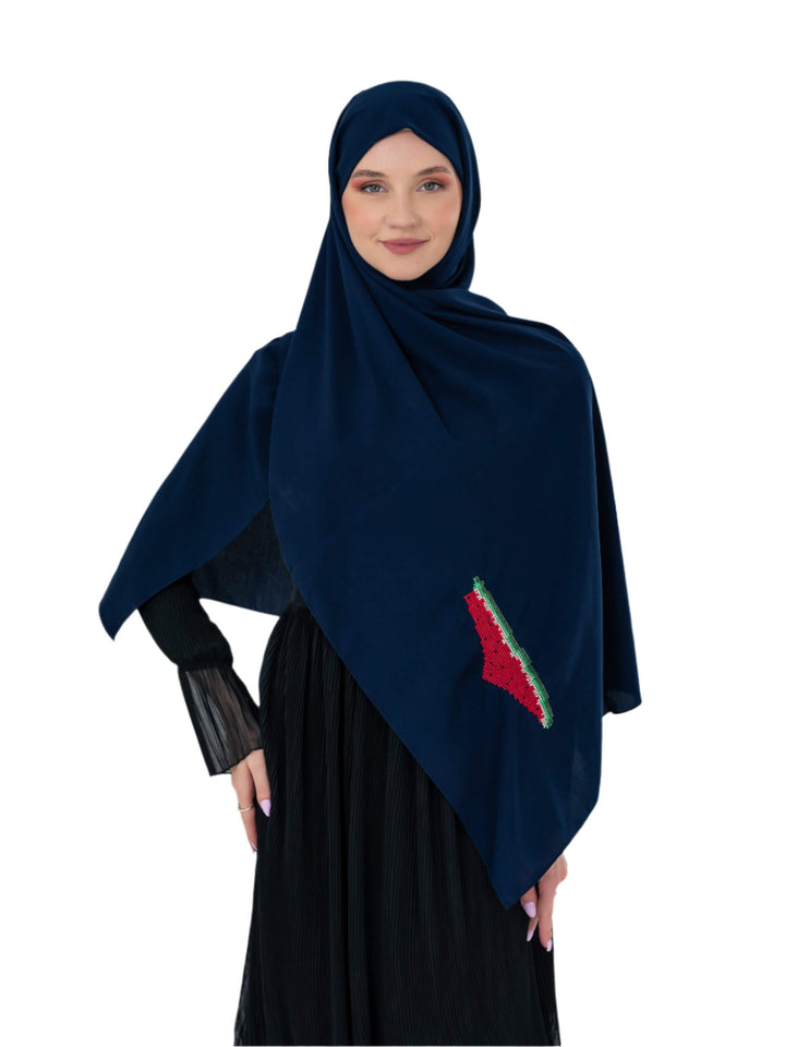 Woman wearing a dark blue hijab with a red and green design on a white background