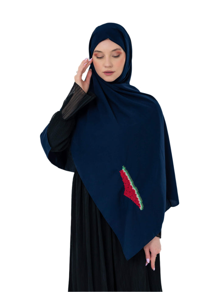 Woman wearing a dark blue hijab with a red and green design on a white background