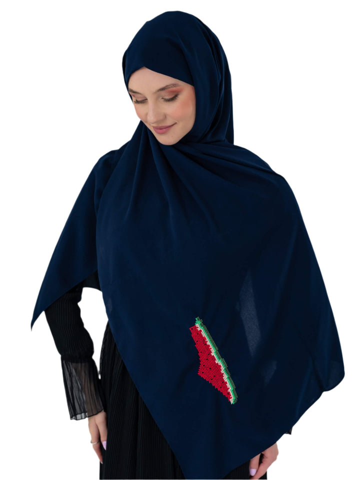 Woman wearing a dark blue hijab with a red and green design on a white background